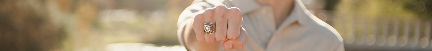 a student holds out his fist displaying his Texas State ring
